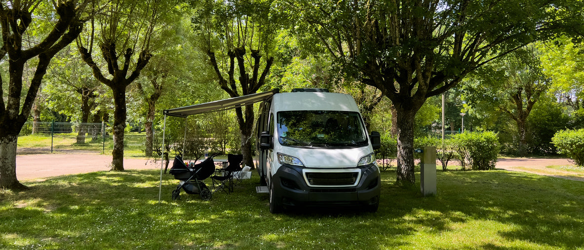 Van with an extended awning in a park setting