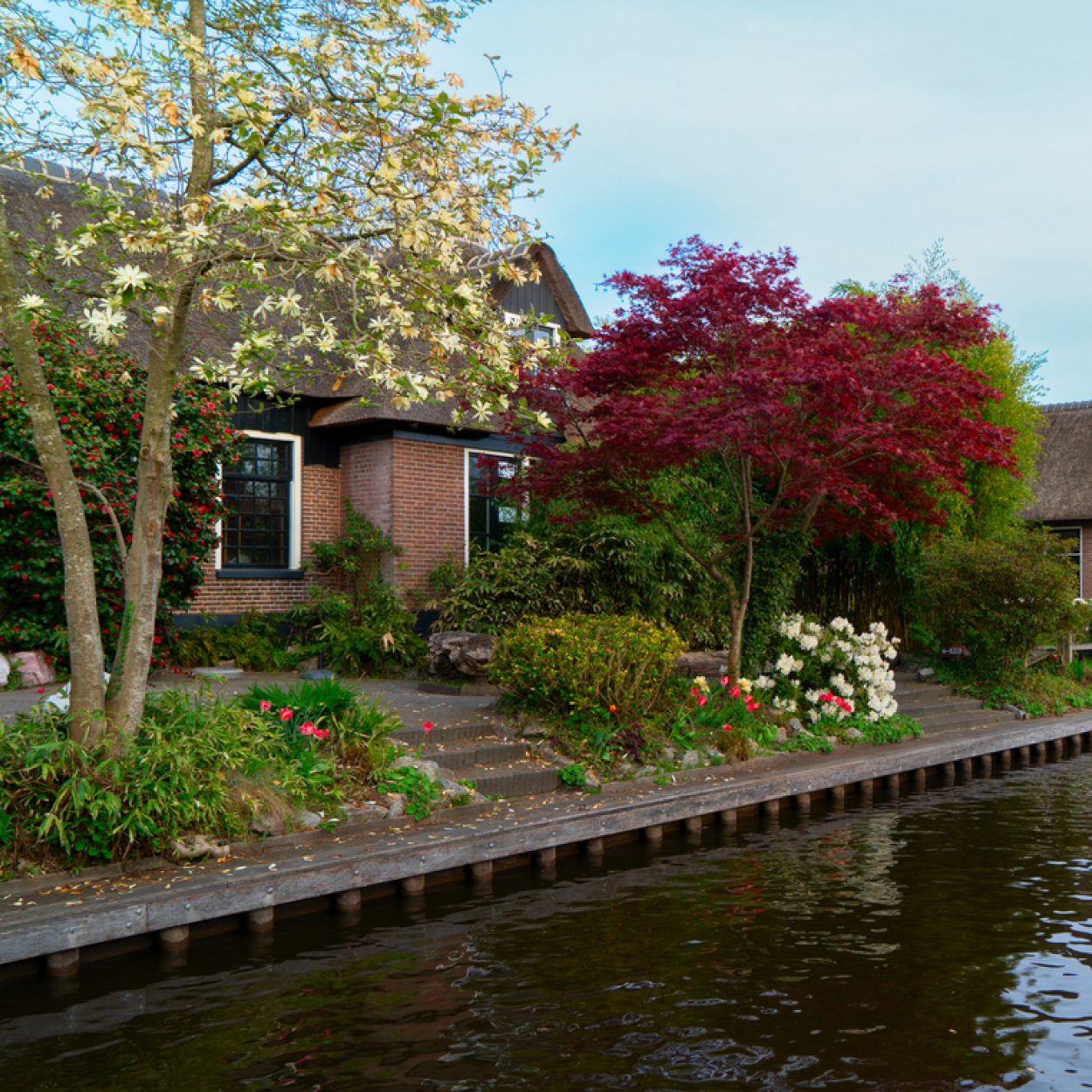 Traditional Dutch house with a garden by a canal