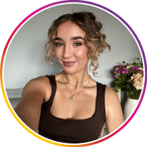 Woman with curly hair wearing a brown tank top indoors