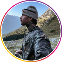 Person standing in a mountainous landscape with a scenic view.