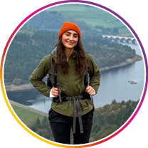 Woman hiking with a scenic background of mountains and water.