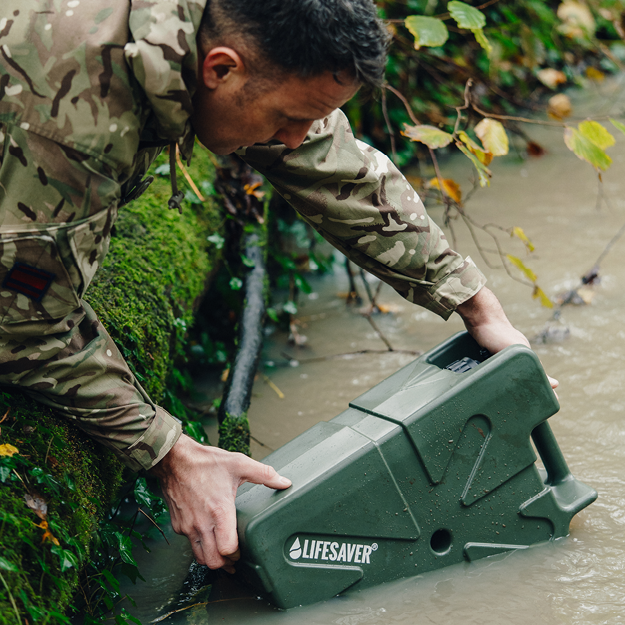 Person in camouflage holding a green 'Lifesaver' device in water